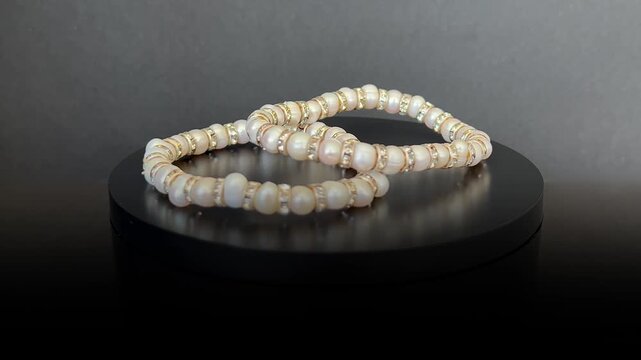 Pulseras de perlas girando 360 grados sobre base giratoria negra