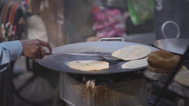 Aloo paratha cooking on street tawa, Delhi street food aloo paratha making, Indian vendor cooking paratha on tawa, Hot stuffed paratha frying roadside stock video.