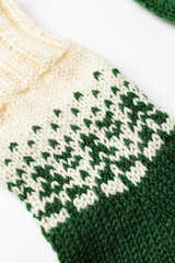 Fototapeta premium Close-up of a handmade knitted sock with green and white wool pattern.