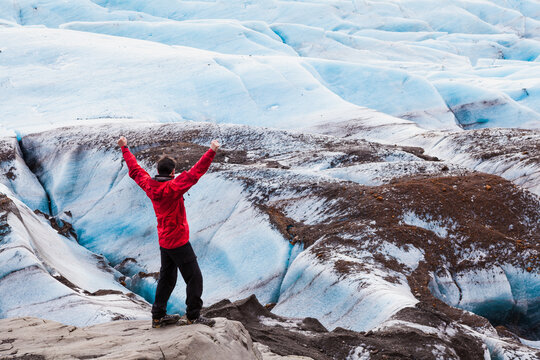 Hiker with arms outstretched at  Svinafellsjokull glacier in Skaftafell, Iceland