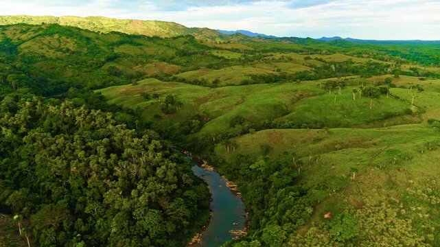 A wild river stream in a mountain forest. River in the mountains. Beautiful natural scenery. Blue-green water among forest and rocky shore, aerial view. Picturesque summer landscape of tropical nature