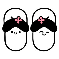Fototapeta premium A cute pair of cartoon slippers with smiling faces and pink flowers on their black hats