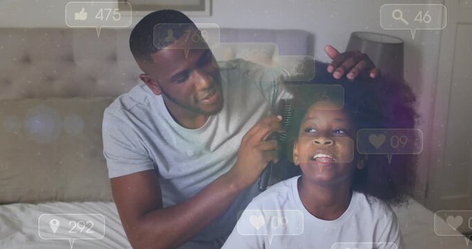 Father placing wide-tooth brush, detangling daughter's hair on bed, social media likes appearing