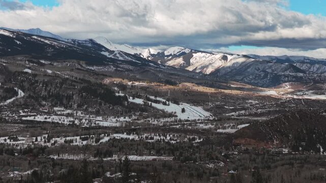 Buttermilk Ski resort snowboarding ski halfpipe Aspen Snowmass ski town winter sunny cloudy morning aerial drone Colorado ski trail runs Maroon Bells Wilderness Aspen Airport forward pan up motion