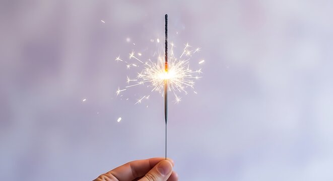 one hand holding a sparkling party sparkler stick