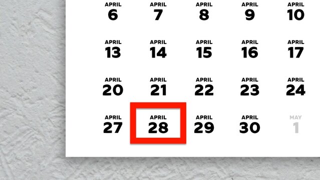 Close-up of the date April 28th marked with a red cursor on the wall calendar 2026