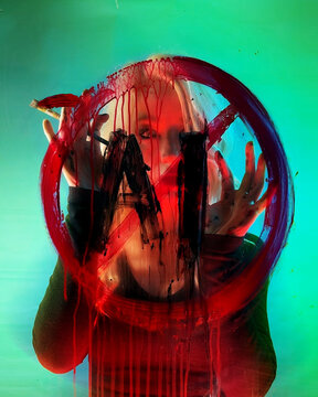 An woman holding a Paintbrush is against Artificial Intelligence with an Anti-AI symbol Painted on Glass for a statement against the new technology.