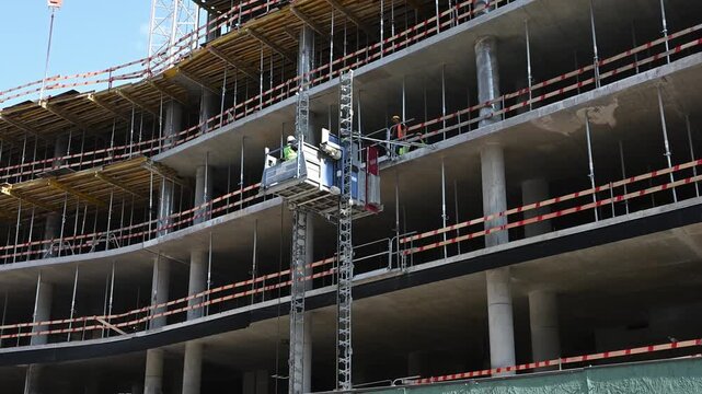 Building Construction with External Freight Lift and Workers