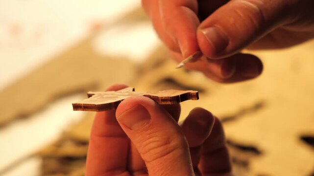 A man smears a wooden part with PVA glue in close-up. The creative process of creating DIY crafts. Gluing a world map from individual pieces of countries. Hobby concept. Carpentry. High quality 4K.