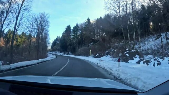 Car POV driving on a mountain stada surrounded by snow. Video shot on Mount Bondone, in Trentino, during a sunny late winter day