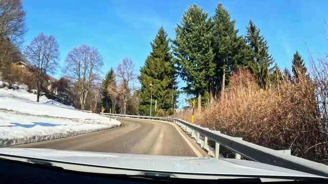 Car POV driving on a mountain stada surrounded by snow. Video shot on Mount Bondone, in Trentino, during a sunny late winter day