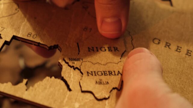 Male hands take out a laser-cut piece from a sheet of plywood to assemble a decorative wooden world map. The creative process of creating DIY crafts. Hobby concept. Carpentry. High quality 4K footage.