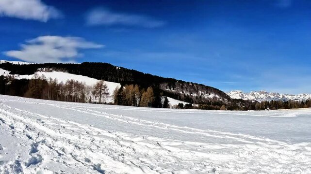 Panning snow-capped mountain panorama on a sunny day. Video shot on Mount Bondone, in Trentino, during a sunny late winter day
