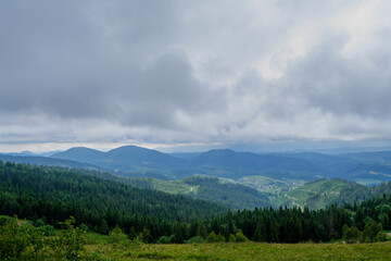 Fototapeta premium Panoramic Mountain Landscape with Dense Forests and Cloudy Sky