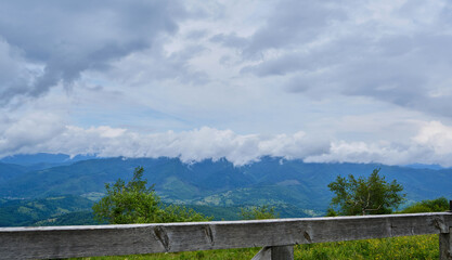 Fototapeta premium Wooden Fence on Mountain Peak Overlooking Clouds