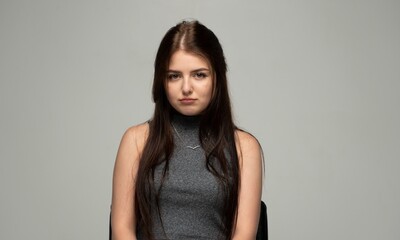 Naklejka premium Young woman feeling sad, showing disappointment and emotional distress in a studio portrait