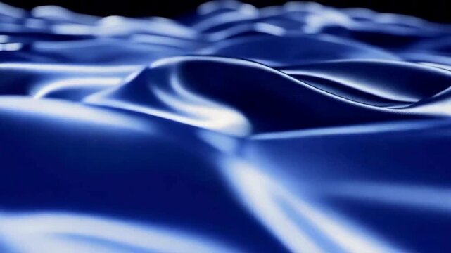 Smooth Dark Blue Silk Fabric Waving in Slow Motion. Close up of luxurious dark blue satin or silk material rippling and moving slowly, creating soft folds and shadows.