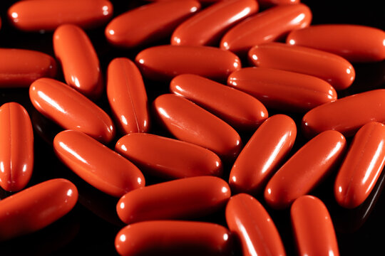 Red ubiquinol coenzyme Q10 Kaneka capsules macro on black background
