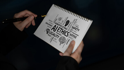 A close-up of hands holding a notebook filled with keywords reflecting on ethics in technology. This image symbolizes the ongoing dialogue surrounding moral implications and innovations. Tessel © InfiniteFlow