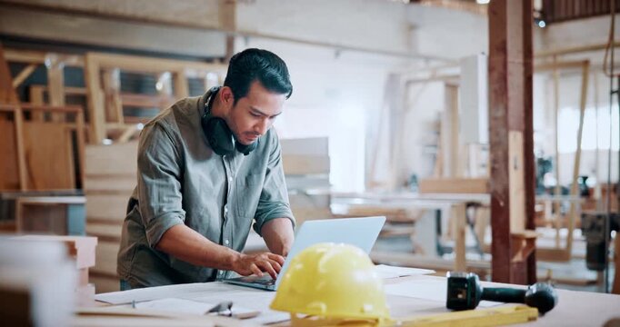 Carpentry, typing and man with laptop in workshop for woodwork order, design review and inventory. Timber manufacturing, carpenter and tech for client email, project invoice and furniture production