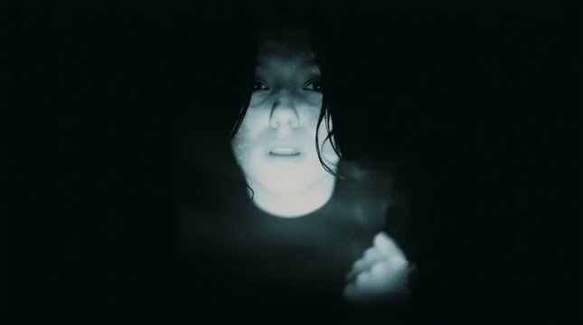 Mysterious ghostly figure emerging from deep darkness. A haunting, cinematic portrait of an eerie person with a pale face. Unseen