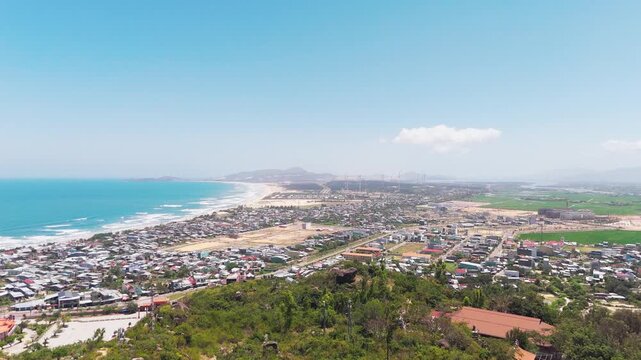 Sweeping Aerial Drone Panorama of Quy Nhon Coastal City, Sandy Beach and Dunes Seen from Thien Hung Buddha Viewpoint, Binh Dinh Province, Central Vietnam, Southeast Asia
