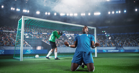 Naklejka premium Black Male Soccer Striker Drops to His Knees in Front of the Net After Scoring in a Major International Championship Match, While the Goalkeeper Turns Away Inside a Packed World Football Stadium.