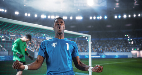 Black Male Soccer Player Clenches Both Fists and Shouts in Triumph Beside the Goal After Scoring in an International Championship Match, as the Goalkeeper Lowers His Head in a Packed World Stadium. © Gorodenkoff