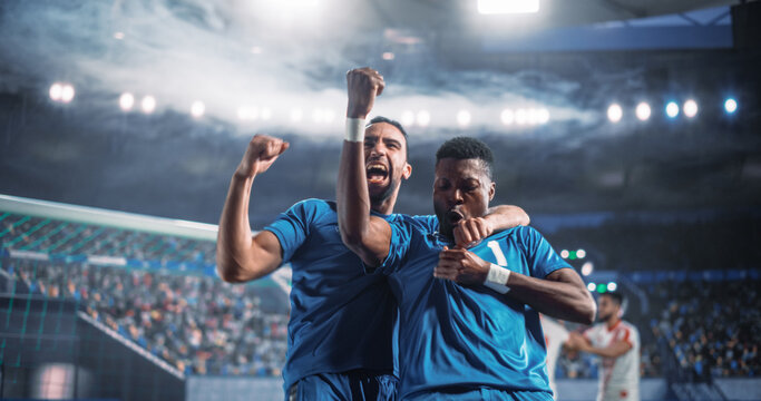 Black Male Soccer Teammates Celebrate a Crucial Goal Beside the Net During a Professional International Tournament Match, Raising Clenched Fists as Rivals Fade in the Background of a World Stadium.