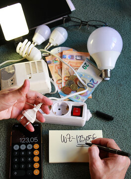 Luz, electricidad, enchufe y dinero para factura de consumo y subida coste el&eacute;ctrico y precio con calculadora y contabilidad