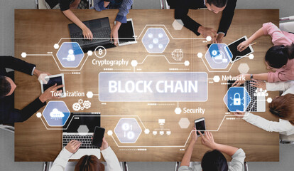 Aerial view of a collaborative team meeting discussing blockchain technology, featuring visual...
