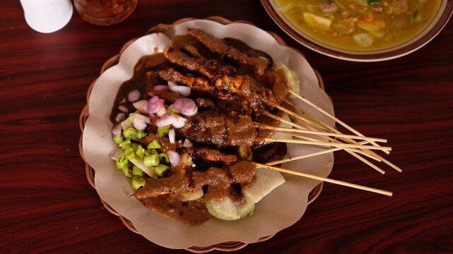 Delicious grilled chicken satay with savory peanut sauce, authentic Indonesian street food skewers