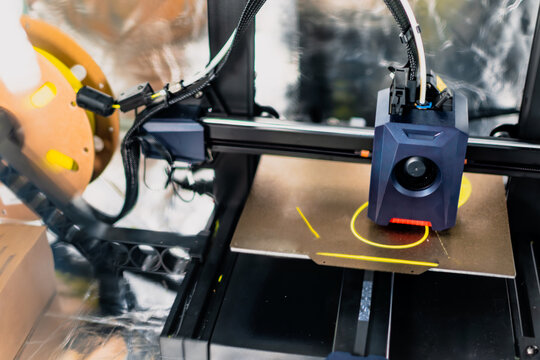 3d printer printing an object on the tray with filament