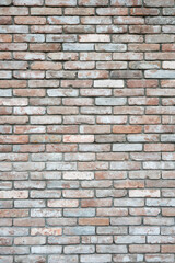 Fototapeta premium Vintage loft style brick wall texture with a mix of red, white, and grey bricks. Rustic reclaimed brickwork background, weathered masonry surface for architectural projects.