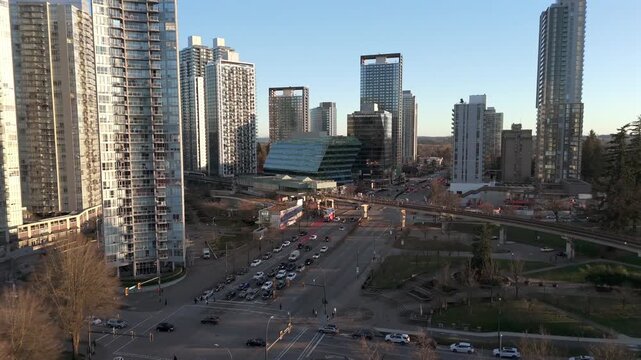 High-rise Modern Buildings And SkyTrain King George Subway Station Along Surrey City Centre In British Columbia, Canada. Aerial Pullback Shot