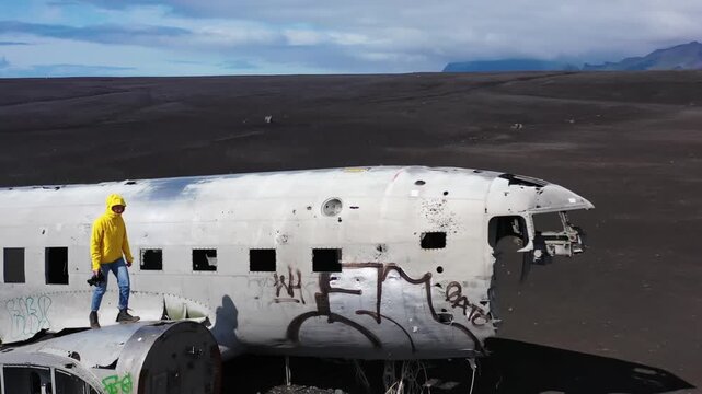 Aerial view of abandoned airplane wreckage on black sand beach in Iceland