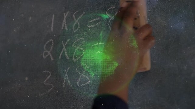 White particles and spinning globe against close up of girl hands erasing blackboard with a duster
