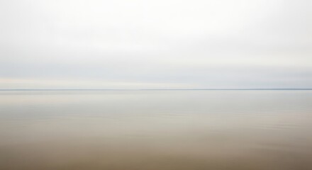 Fototapeta premium Calm sea with gray sky and reflection on water surface ocean