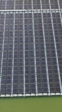 High angle view of floating PV panels and closed-house poultry farm for energy-efficient livestock production.