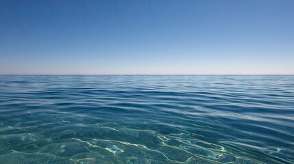 Fototapeta premium Clear blue water surface stretches out toward the distant horizon beneath a bright sky