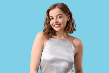 Obraz premium Smiling young woman with bob hairstyle on blue background
