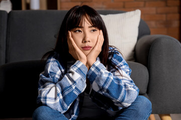 Obraz premium Young Asian woman with suicidal thoughts sitting at home
