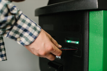 Naklejka premium Person inserting bank card into atm for transaction