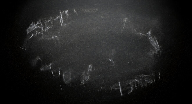 Empty blackboard with chalk smudges and dust, perfect for adding custom text and graphics for educational or creative concepts.