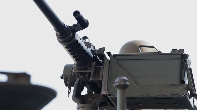 Soldier operating heavy machine gun on military vehicle
