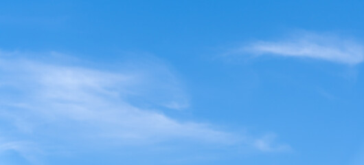 Obraz premium Low angle view and full frame of beautiful light blue sky with thin white clouds in the afternoon on sunny day used as natural background texture in decorative art work