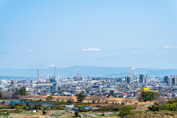 Naklejka premium View of an industrial city Fujinomiya in japan with factory chimneys and residential buildings under a clear blue sky. concept of urban development, manufacturing industry and suburban landscape.