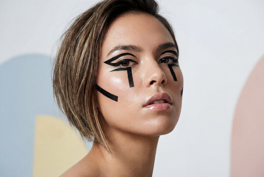 Young woman with asymmetrical lob and graphic black glitch eyeliner for avant garde make-up editorial or futuristic beauty fashion concept