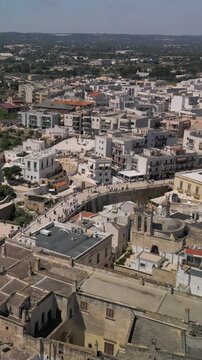 Vertical aerial view of Polignano a Mare, panorama of the buildings the old town and Ponte Borbonico di Lama Monachile bridge, Puglia, Italy