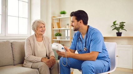 Obraz premium Doctor measuring blood pressure of elderly woman